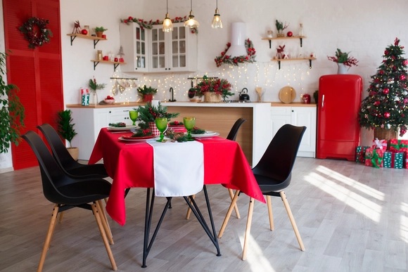 Modernes Kücheninterieur mit festlicher Weihnachtsdekoration und gedecktem Esstisch.
